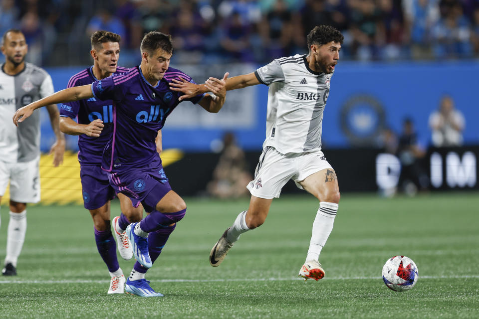 Toronto FC midfielder Jonathan Osorio, right, beats Charlotte FC midfielder Andrew Privett to the ball during the first half of an MLS soccer match in Charlotte, N.C., Wednesday, Oct. 4, 2023. (AP Photo/Nell Redmond)