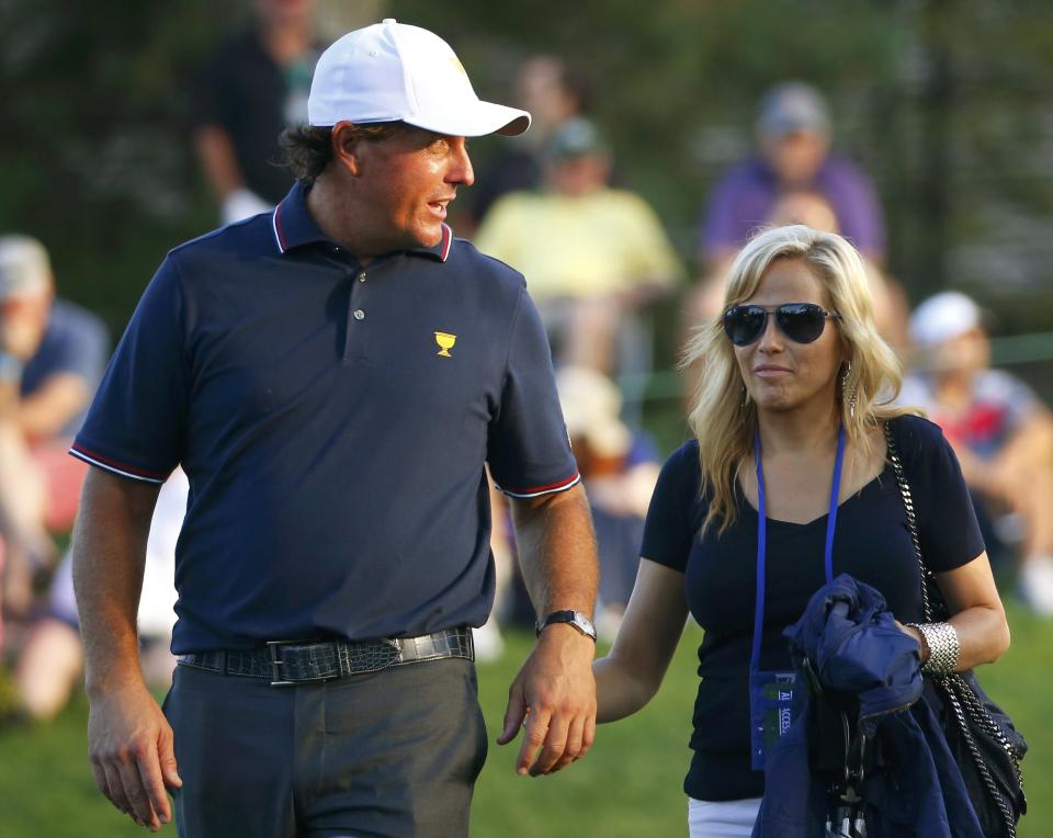 U.S. team member Phil Mickelson walks with his wife Amy after losing his first round match in the opening Four-ball matches for the 2013 Presidents Cup golf tournament at Muirfield Village Golf Club in Dublin, Ohio October 3, 2013. REUTERS/Jeff Haynes (UNITED STATES - Tags: SPORT GOLF)