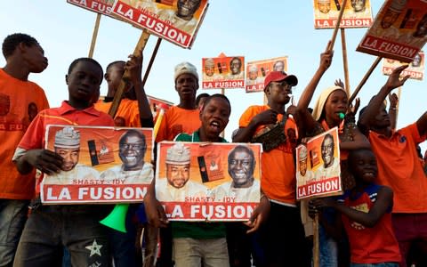 Supporters of Senegal presidential election candidate Idrissa Seck wave placards during a rally in Dakar - Credit: AFP