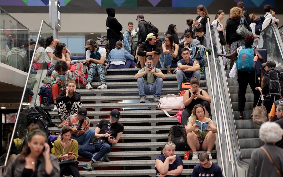 Passengers waiting on a staircase for their train to depart at Gare Montparnasse station in Paris on July 26, 2024