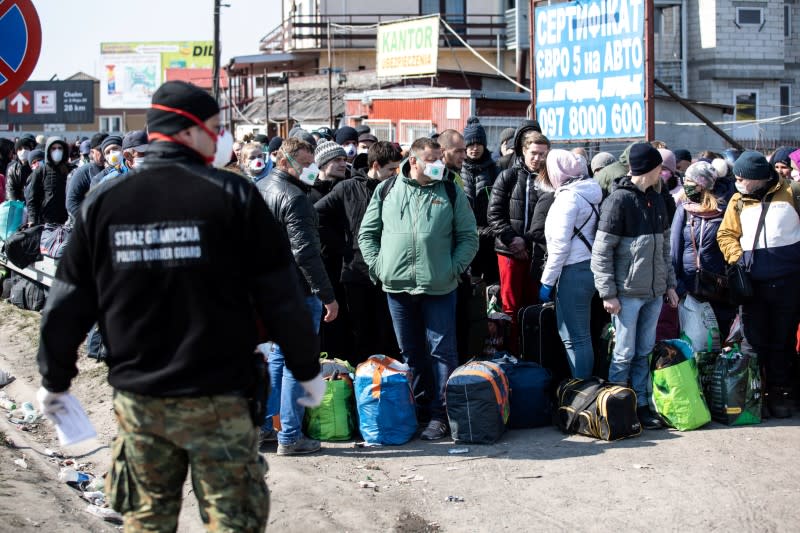 People queue to cross to Ukraine at the border crossing in Dorohusk