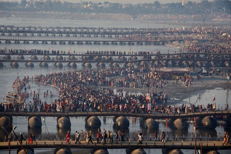 Hindu devotees gather on the shores of the River Ganges as it meets the Yamuna river (background) in Allahabad, on February 9, 2013. Tens of millions of Hindu pilgrims are preparing to cleanse their sins with a plunge into the sacred River Ganges, ahead of the most auspicious day of the world's largest religious festival