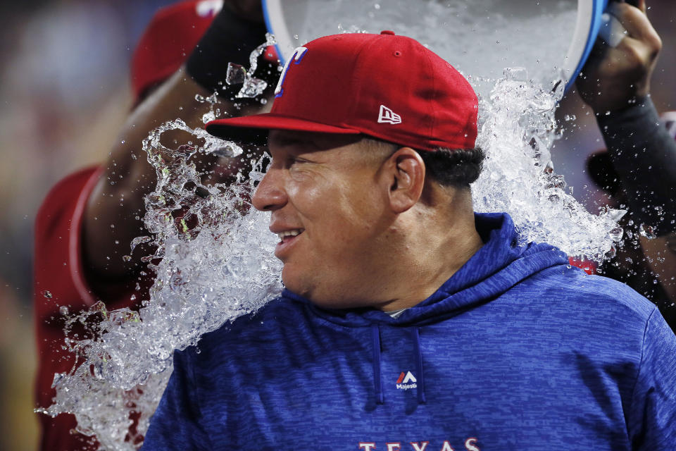 FILE - In this Aug. 7, 2018 file photo, Texas Rangers starting pitcher Bartolo Colon is doused after his 246th career win, the most by a pitcher born in Latin America, after the team's baseball game against the Seattle Mariners, in Arlington, Texas. With each day that passes without baseball activity, the chances that the Dominican, who celebrates his 47th birthday on Sunday, May 24, 2020, could pitch again in the Major Leagues diminishes. (AP Photo/Brandon Wade, File)