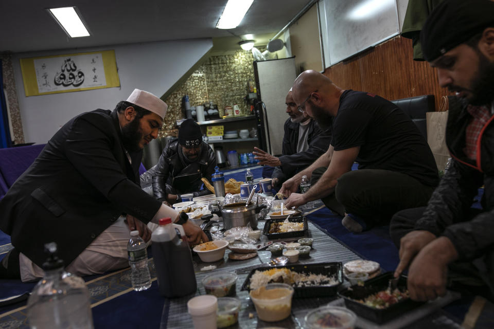 Ahmed Soliman, 33, right, together with Mohamed Bahe, 36, second right, end their day of fasting over a meal with Imam Abdullah Salem, 26, left, between volunteering with Muslims Giving Back, on Tuesday, April 28, 2020, in the Bay Ridge neighborhood of Brooklyn, New York. (AP Photo/Wong Maye-E)