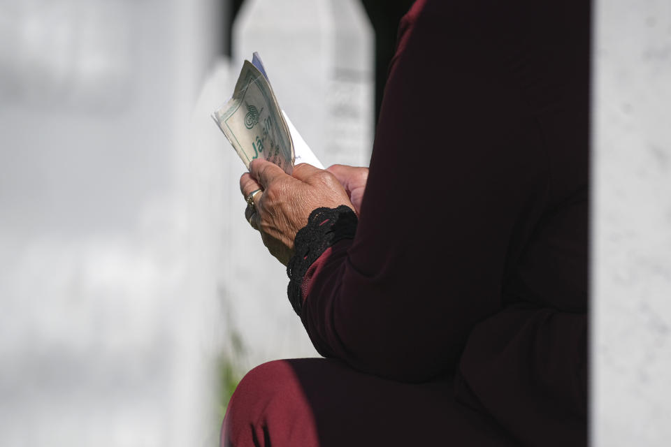 A woman prays in Potocari, near Srebrenica, Bosnia, Saturday, July 11, 2020. Nine newly found and identified men and boys were laid to rest as Bosnians commemorate 25 years since more than 8,000 Bosnian Muslims perished in 10 days of slaughter, after Srebrenica was overrun by Bosnian Serb forces during the closing months of the country's 1992-95 fratricidal war, in Europe's worst post-WWII massacre. (AP Photo/Kemal Softic)