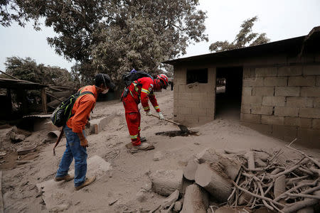 A rescue worker inspects an area affected by eruption from Fuego volcano in the community of San Miguel Los Lotes in Escuintla, Guatemala June 4, 2018. REUTERS/Luis Echeverria