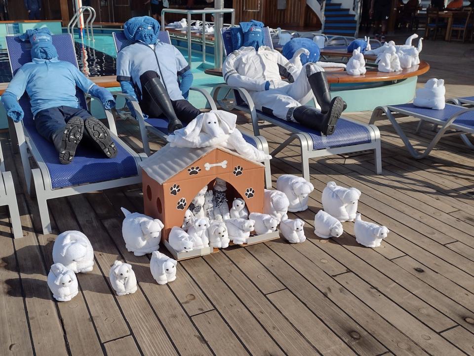 A collection of animals made from white towels on the deck of a Carnival cruise ship.