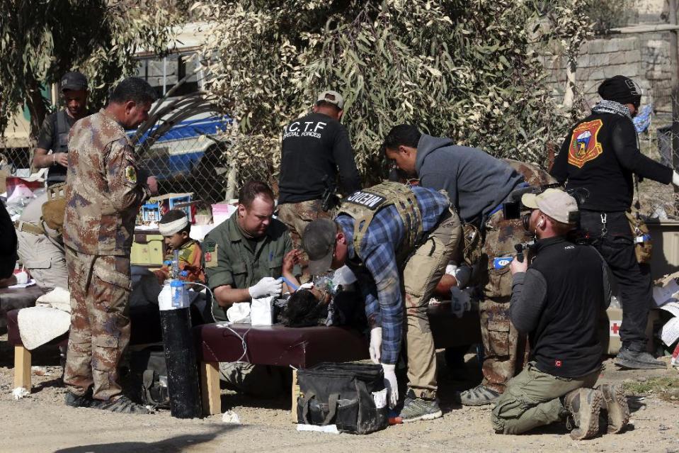 Army paramedics give first aid to displaced civilians, injured in IS mortar bombing, during fighting between Iraqi security forces and Islamic State militants, in the western side of Mosul, Iraq, Sunday, Feb. 26. 2017. (AP Photo/ Khalid Mohammed)