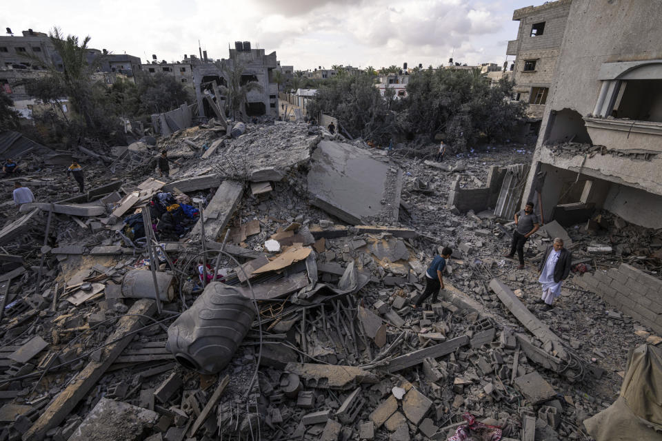 Palestinians inspect the rubble at the site of an airstrike that the Israeli military said targeted the house of an Islamic Jihad member, in Deir al-Balah, central Gaza Strip, Saturday, May 13, 2023. (AP Photo/Fatima Shbair)