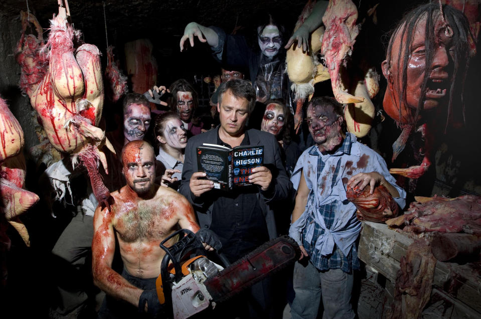 Comedian and author Charlie Higson is surrounded by 'zombies' as he signs copies of his new children's book 'The Enemy' at the London Bridge Experience.   (Photo by Carl Court/PA Images via Getty Images)