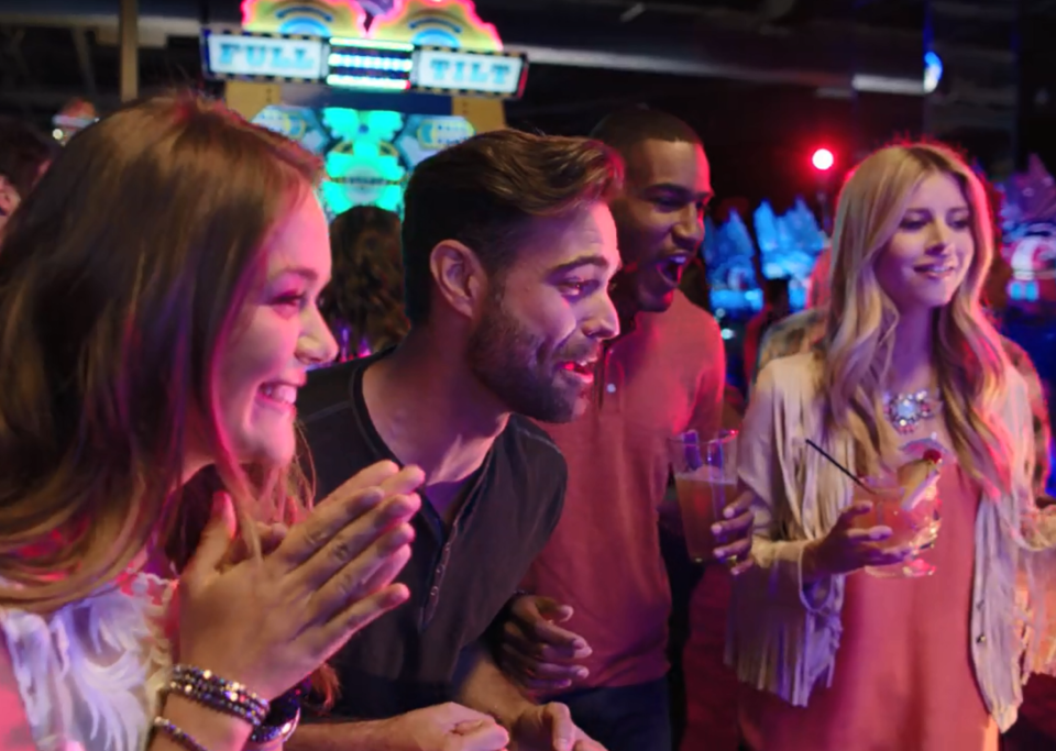 Adults playing in Dave & Buster's Million Dollar Midway arcade.