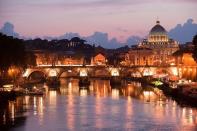 An overview of Saint Peter's basilica at the Vatican, from the Tiber river, at dusk in Rome, Italy. Every year around 15 milions of tourists are estimated to visit Rome.