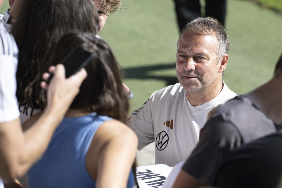 Germany's national soccer coach Hansi Flick signs autographs in Wolfsburg, Germany, Sunday, Sept. 10, 2023. Germany was jeered by its home crowd Saturday after slumping to a 4-1 loss to Japan to pile yet more pressure on coach Hansi Flick, nine months out from hosting the European Championship. (Swen Pfoertner/dpa via AP)