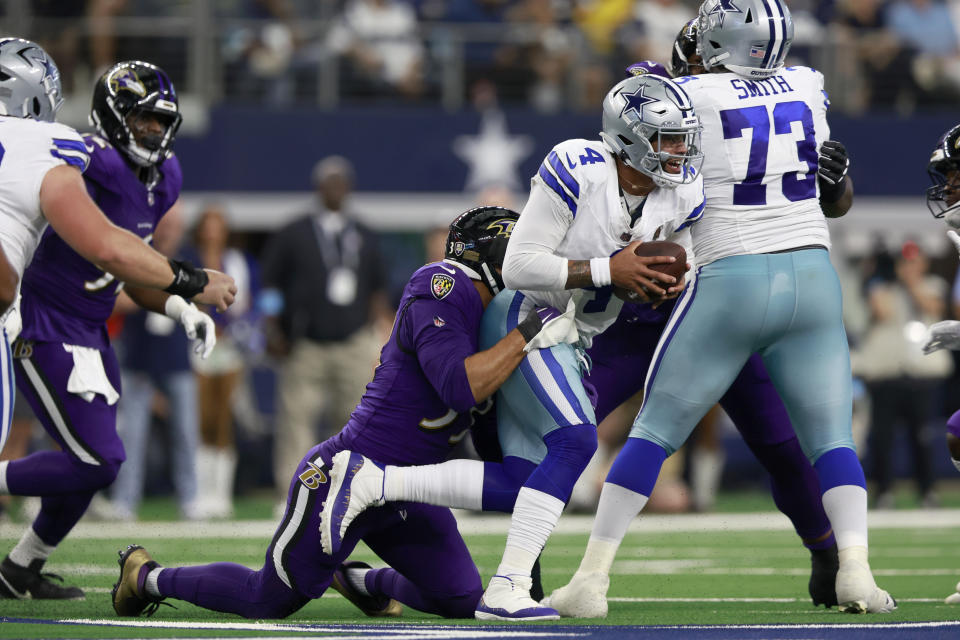 Baltimore Ravens linebacker Kyle Van Noy, left, sacks Dallas Cowboys quarterback Dak Prescott (4) in the first half of an NFL football game in Arlington, Texas, Sunday, Sept. 22, 2024. (AP Photo/Gareth Patterson)