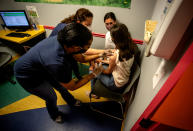 Middle school student Elise Robinson receives her first coronavirus vaccination on Wednesday, May 12, 2021, in Decatur, Ga. Hundreds of children, ages 12 to 15, received the Pfizer vaccine at the DeKalb Pediatric Center, just days after it was approved for use within their age group. (AP Photo/Ron Harris)