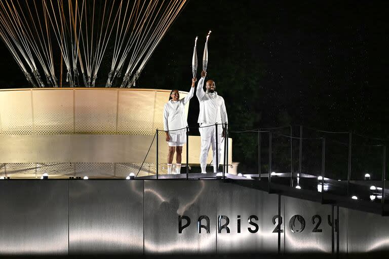 La ex velocista Marie-José Perec y el ex judoca Teddy Riner en el paso final del recorrido de miles de kilómetros de la antorcha olímpica, que partió de Grecia y llegó a París.