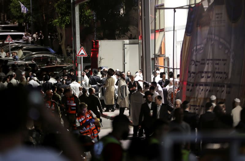 Jewish worshippers and rescue workers stand outside a synagogue in Givat Zeev