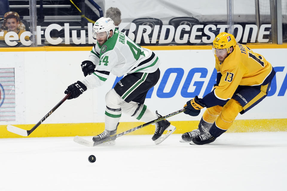 Dallas Stars defenseman Joel Hanley (44) and Nashville Predators center Yakov Trenin (13) battle for the puck in the second period of an NHL hockey game Sunday, April 11, 2021, in Nashville, Tenn. (AP Photo/Mark Humphrey)