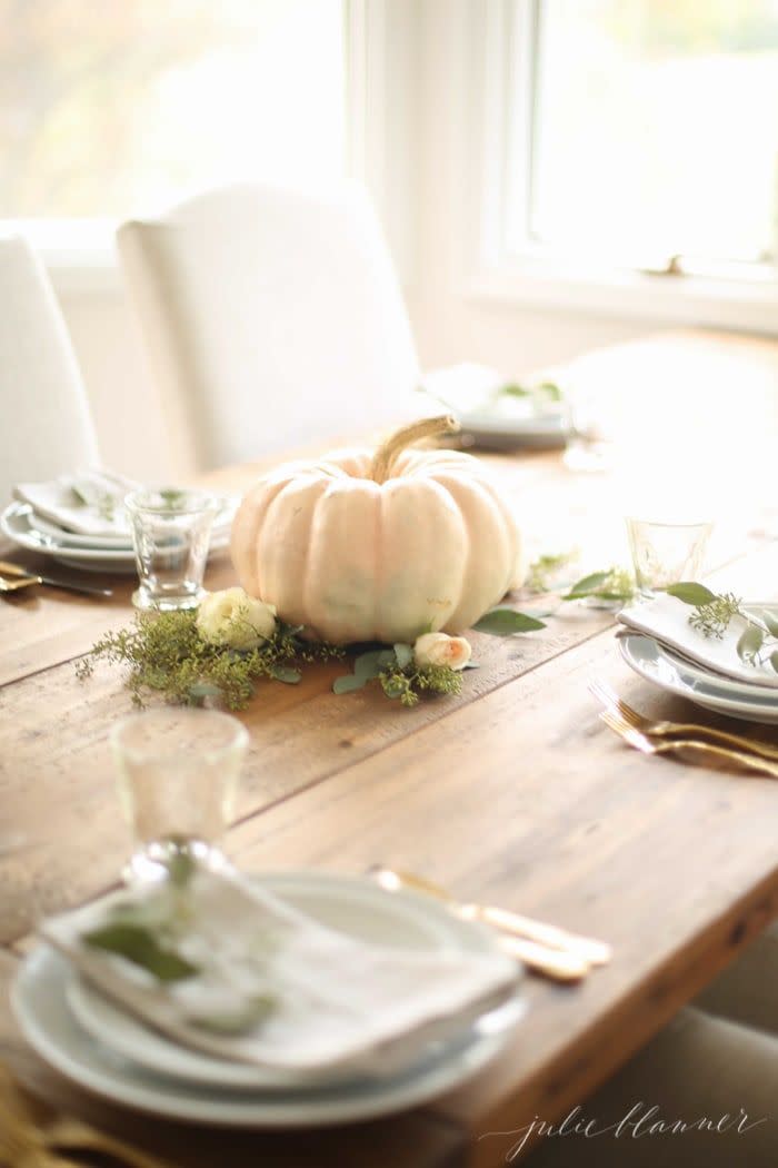 <p>Place an artificial pumpkin on a bed of moss and leafy greens for a simple centerpiece that you can use time and time again.</p><p><em><a href="https://julieblanner.com/easy-thanksgiving-centerpiece/" rel="nofollow noopener" target="_blank" data-ylk="slk:Get the tutorial from Julie Blanner »;elm:context_link;itc:0;sec:content-canvas" class="link ">Get the tutorial from Julie Blanner »</a></em></p>