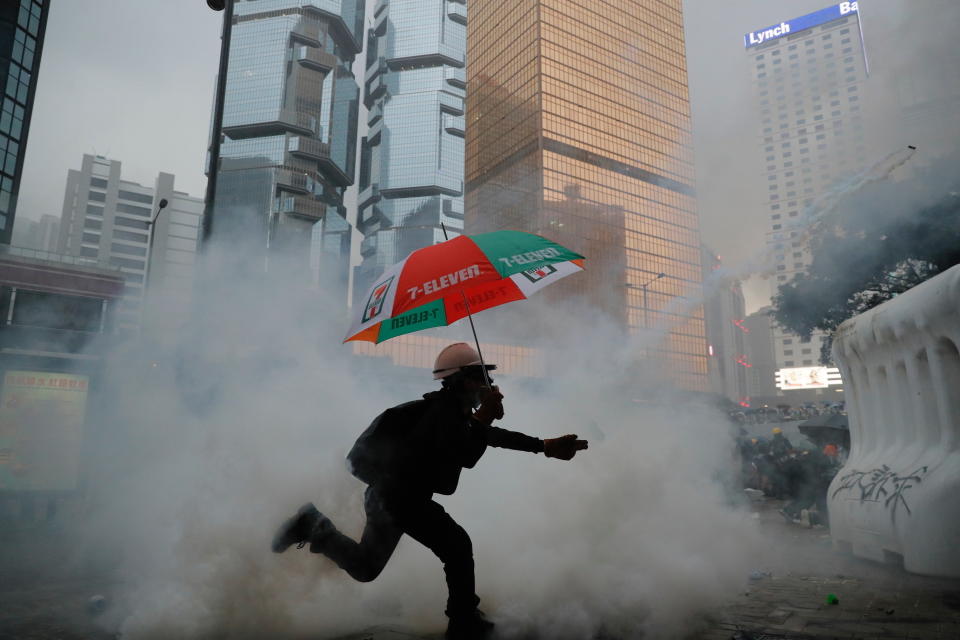 A protestor throws back an exploded tear gas shell at police officers in Hong Kong, Saturday, Aug. 31, 2019. Tear gas, pepper spray and fire returned to the streets of Hong Kong, as police officers clashed with masked pro-democracy protesters in the first notable display of unrest since Hong Kong's top leader announced that she would withdraw a deeply unpopular extradition bill. (AP Photo/Kin Cheung)