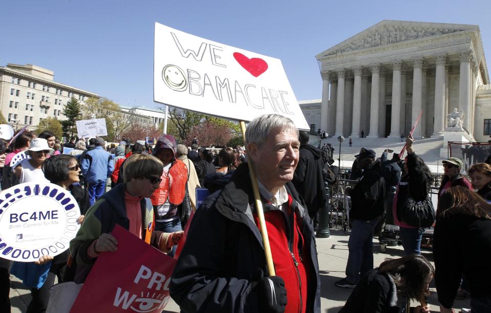 Holding a sign saying "We Love Obamacare" supporters of health care reform rally in front of the Supreme Court in Washington, Tuesday, March 27, 2012, as the court continued hearing arguments on the health care law signed by President Barack Obama. Go ahead, call it Obamacare. Obama’s re-election campaign has lifted an unofficial ban on using the opposition’s derisive term for his health care law. Democratic activists have been chanting, "We love Obamacare," in front of the Supreme Court. And the campaign is selling T-shirts and bumper stickers that proclaim: "I like Obamacare." (AP Photo/Charles Dharapak)