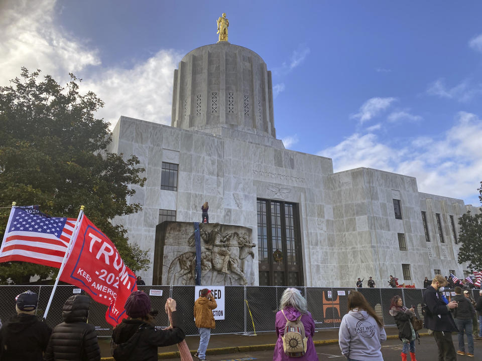 FILE - In this Dec. 21, 2020, file photo, protesters hold a rally outside the Oregon State Capitol in Salem, Ore., as legislators meet for a special session to discuss COVID-19 relief measures. During the protest Republican lawmaker, Rep. Mike Nearman, physically opened the Capitol's door — letting protesters, who clashed with police, gain access to the building. There have been calls for Nearman to resign ahead of the upcoming 2021 Legislative session that begins Tuesday, Jan. 19, 2021. (AP Photo/Sara Cline, File)