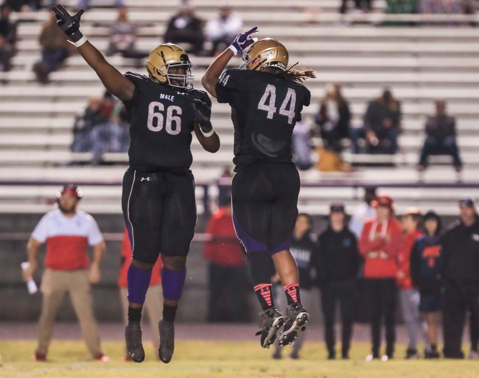 Male's Selah Brown, right, celebrates his tackle with teammate William Spencer as the Bulldogs rolled past visiting Bullitt East 55-14 Friday. Oct. 22, 2021