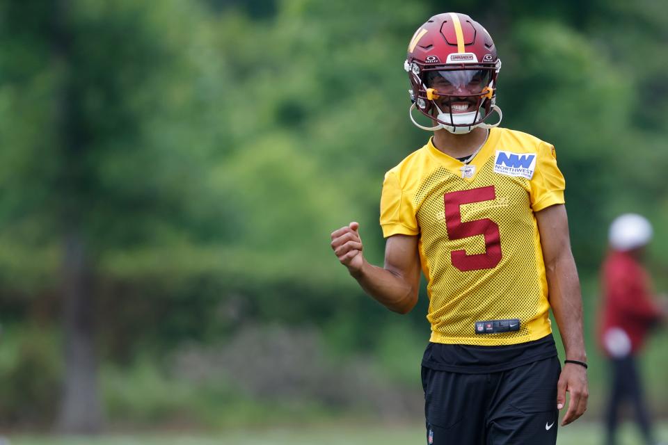 Washington Commanders quarterback Jayden Daniels (5) gestures during OTA workouts at Commanders Park.