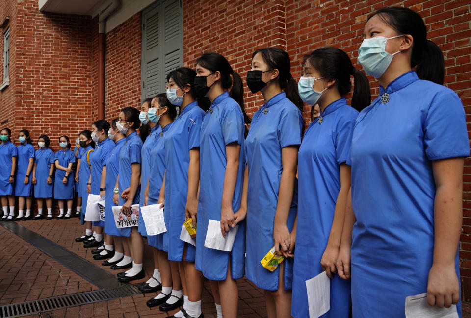 Students form human chain outside St. Paul's Co-Educational College in Hong Kong, Monday, Sept. 9, 2019. Students and alumni of the school protest to pressure the government to meet four demands following a formal withdrawal of the controversial extradition bill. (AP Photo/Vincent Yu)