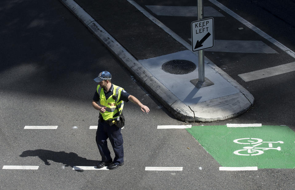 A police officer is seen directing traffic in the Brisbane CBD.