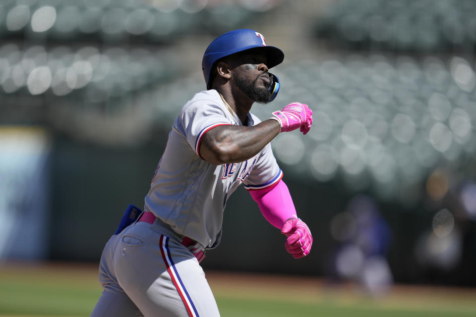 Texas Rangers' Adolis Garcia gestures after hitting a grand slam against the Oakland Athletics during the eighth inning of a baseball game in Oakland, Calif., Sunday, May 14, 2023. (AP Photo/Jeff Chiu)