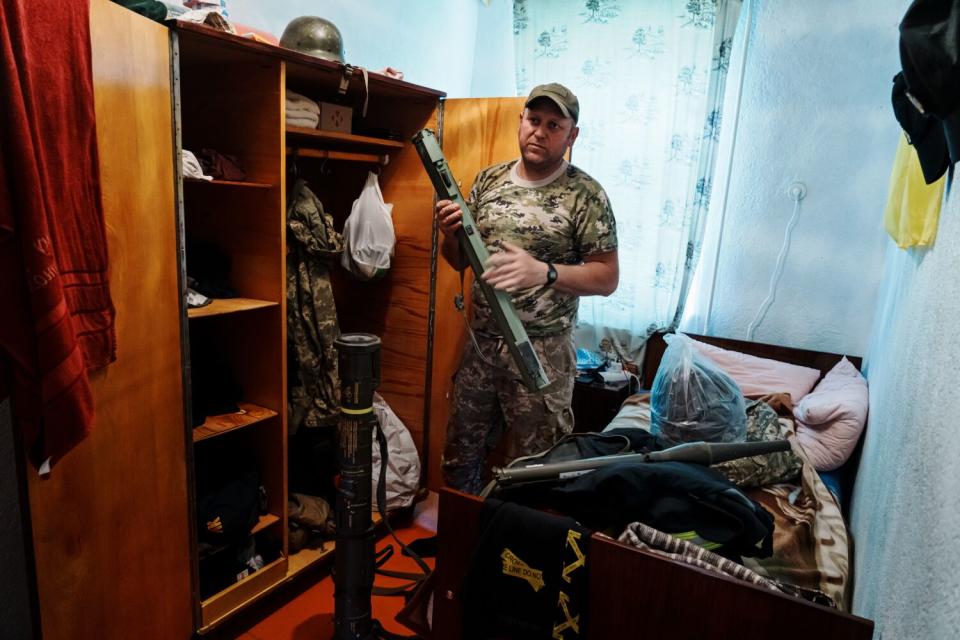 A man stands by an open cupboard