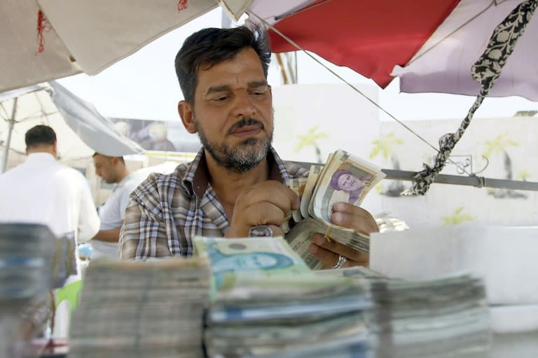 An Iraqi vendor sells Iranian currency on a street in Najaf on August 14, 2018