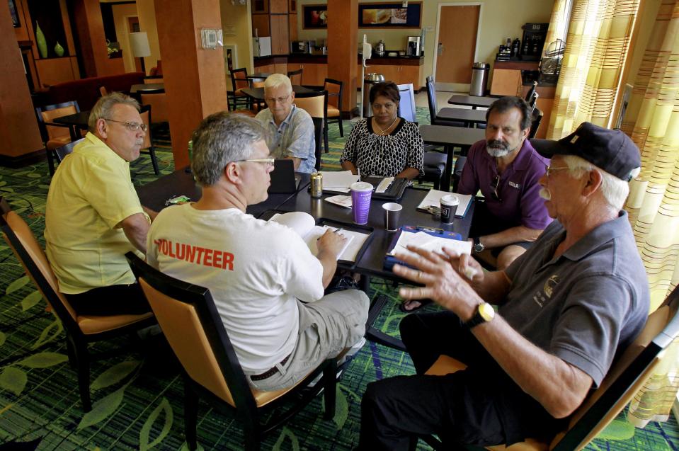 In this Wednesday, July 11, 2012 photo, Terry White, far right, leads a discussion during a business development meeting of former space workers, clockwise from center, John Hoog, Raymond Steele, Kenneth Mark Higginson Jr., Kay Sunderland and Kevin Harrington, in Titusville, Fla. (AP Photo/John Raoux)