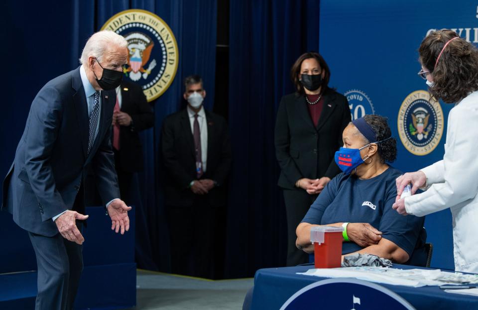 President Joe Biden greets Linda Bussey (2nd R), a Safeway manager, as she prepares to receive a Covid-19 vaccine from nurse Elizabeth Galloway (R).  / Credit: SAUL LOEB/AFP via Getty Images