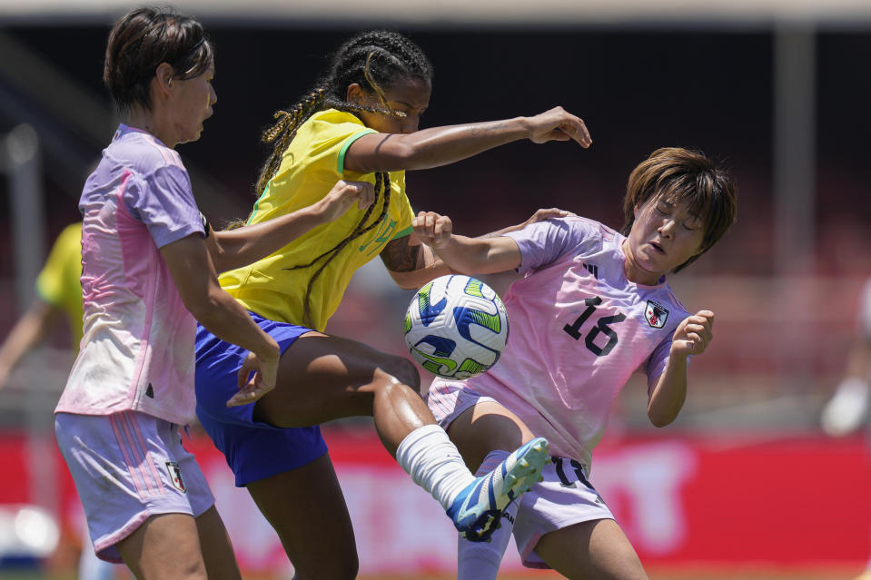 Brazil's Geyse, center, fights for a ball with Japan's Saki Kumagi, left, and Honoka Hayashi during a women's friendly soccer match at Morumbi stadium in Sao Paulo, Brazil, Sunday, Dec. 3, 2023. (AP Photo/Andre Penner)