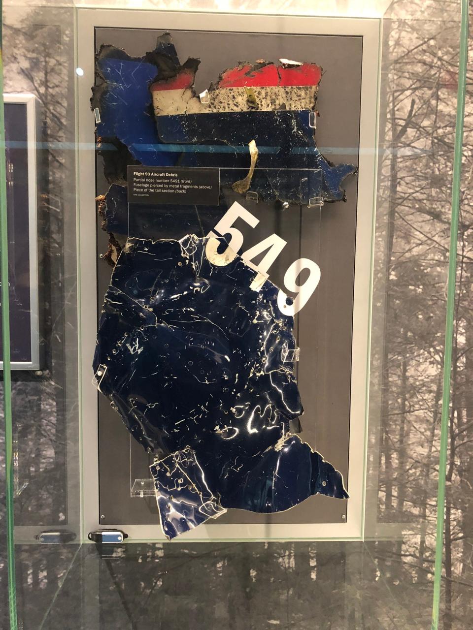 A scarred and crumpled section of Flight 93's fuselage shows the first three digits of the plane's ID number 5491 in a display at the Flight 93 National Memorial Visitor Center.