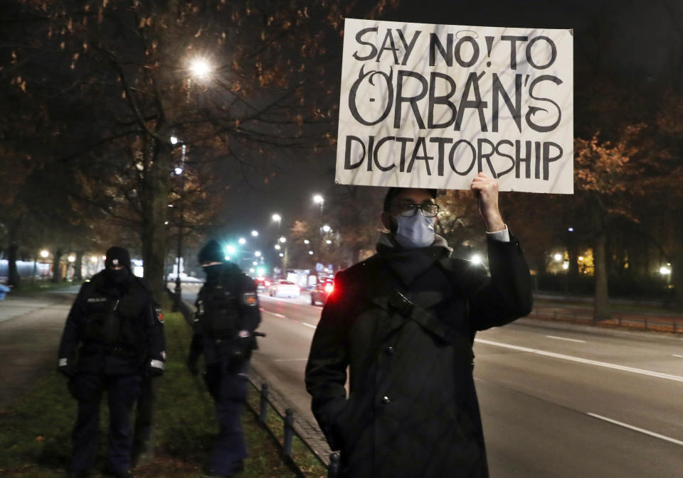 A man protests the policies of Hungarian Prime Minister Viktor Orban during Orban's talks with Poland's Prime Minister Mateusz Morawiecki in Warsaw, Poland, Monday, Nov. 30, 2020. The prime ministers of Poland and Hungary are meeting to discuss their threat to veto the European Union's next budget and massive pandemic aid package that links the disbursement of EU funds to the members' rule of law standards. (AP Photo/Czarek Sokolowski)