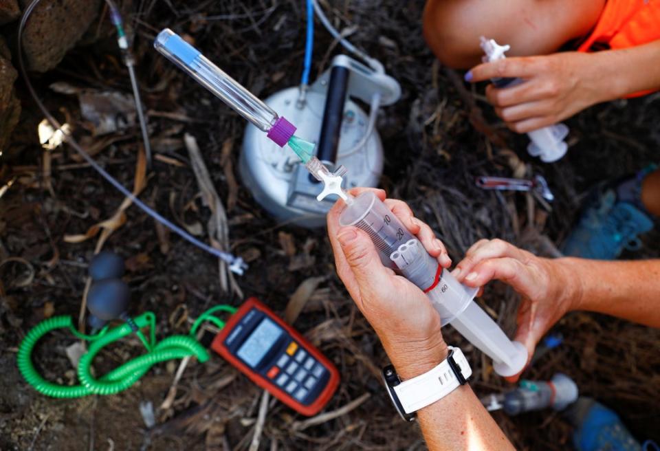 Two volcanologists from the Volcanological Institute of the Canary Islands collect gas samples in Tazacorte (REUTERS)