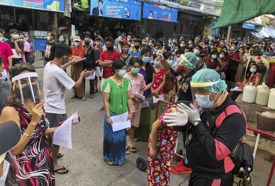 People stand in lines to get COVID-19 tests in Samut Sakhon, South of Bangkok, Thailand, Sunday, Dec. 20, 2020. Thailand reported more than 500 new coronavirus cases on Saturday, the highest daily tally in a country that had largely brought the pandemic under control. (AP Photo/Jerry Harmer)