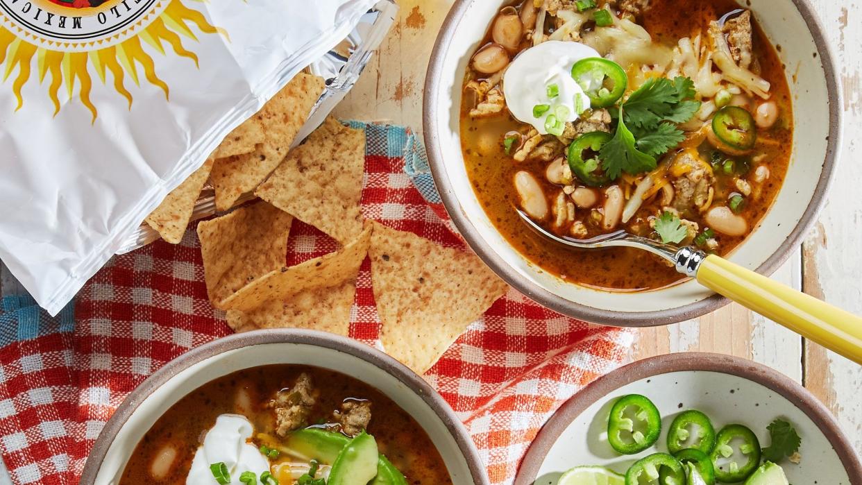 classic white chicken chili in bowls with sour cream cilantro and sliced avocado on top