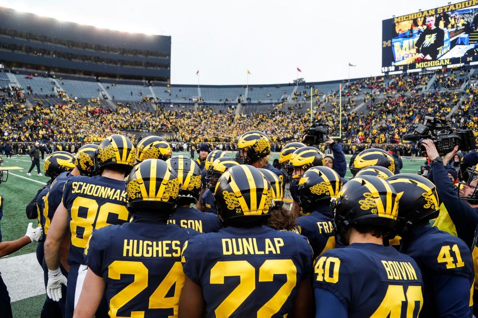 Michigan players huddle during warmups before the Ohio State game at Michigan Stadium in Ann Arbor on Saturday, Nov. 27, 2021.