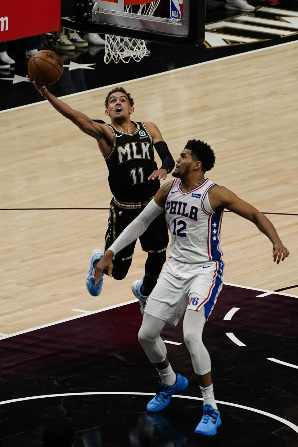 Atlanta Hawks guard Trae Young (11) goes up to shoot against Philadelphia 76ers' Tobias Harris (12) during the second half of Game 6 of an NBA basketball Eastern Conference semifinal series Friday, June 18, 2021, in Atlanta. (AP Photo/John Bazemore)