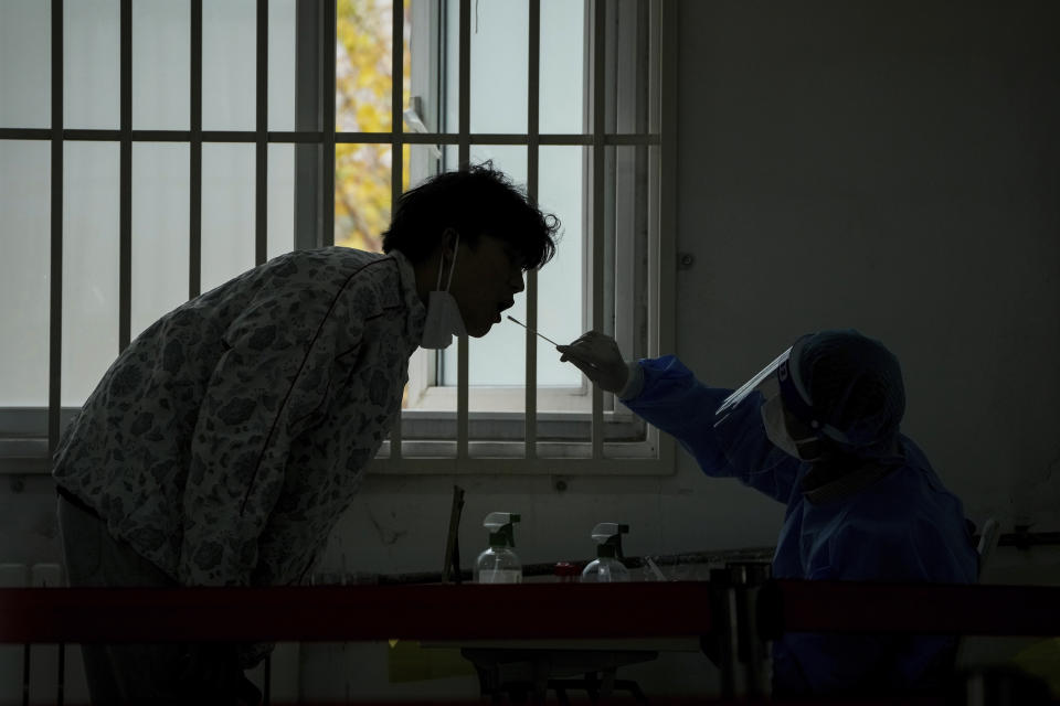 A man gets his routine COVID-19 throat swab at a coronavirus testing site in Beijing, Sunday, Oct. 30, 2022. (AP Photo/Andy Wong)