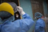 Giseli del Pilar, 29, listens to Doctor Jose Pimentel during a house-to-house coronavirus testing drive in Villa el Salvador, on the outskirts of Lima, Peru, Tuesday, June 30, 2020. (AP Photo/Rodrigo Abd)