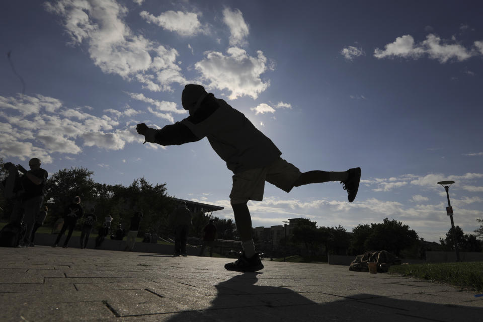 In this Oct. 2, 2019, photo, Biti Arelong performs tai chi at the Salt Lake City Public Library, in Salt Lake City. The participants are homeless people who take part in a free tai chi program run by Bernie and his wife Marita, a retired couple who started the classes three years ago by knocking on tents and peering around grocery carts near the Library to encourage people to join them. (AP Photo/Rick Bowmer)