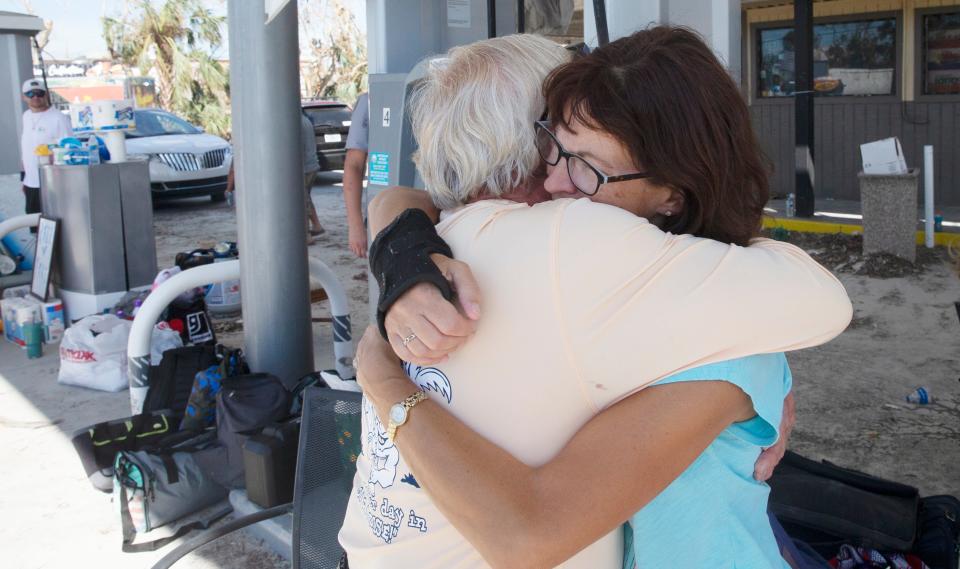 Jean Kanehl, a resident of Fort Myers Beach, hugs Dave Johnston at a reunion spot on nearby San Carlos Island on Monday, Oct. 3, 2022. She and her husband, Fred, were evacuated Monday after riding out Hurricane Ian in their multi-story condo building.