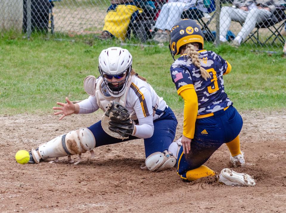 Gaylord's Ava Wells slides safely home while Hartland catcher Sadie Malik attempts to catch the ball and make a tag Saturday, May 11, 2024.