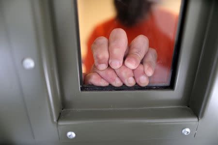 Un detenido de ICE descansa sus manos en la ventana de su celda en el ala de segregación en el centro de detención de inmigración de Adelanto, administrado por Geo Group Inc , en Adelanto, California, Estados Unidos, el 13 de abril de 2017. Roberto Galán, de 33 años, pagó 3.000 dólares a un traficante para que lo introdujera en Estados Unidos desde El Salvador por vez primera cuando era un adolescente en 1997. Desde entonces, ha sido deportado dos veces y ha regresado. REUTERS/Lucy Nicholson