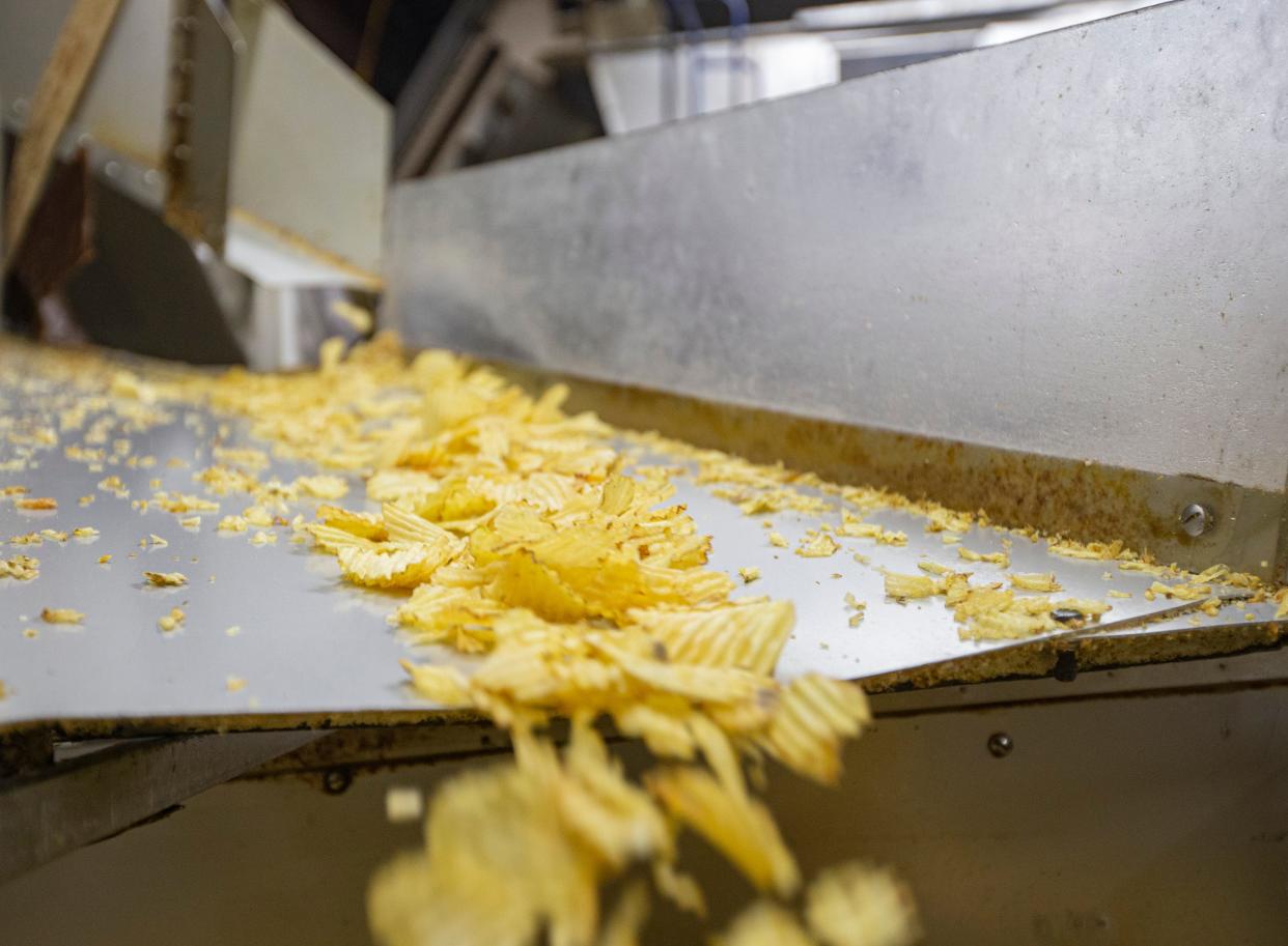 Mrs. Fisher's Potato Chips make their way off the conveyor belt and into containers on Tuesday, Dec. 13, 2022, at Mrs. Fisher's Potato Chips in Rockford.